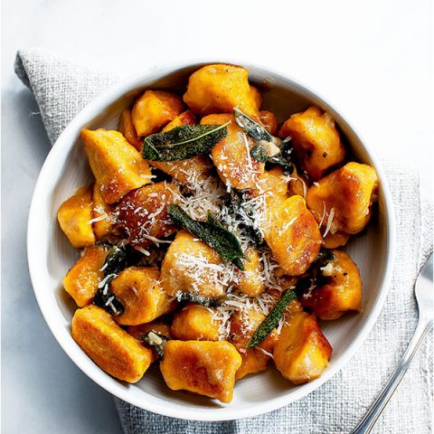 Pumpkin gnocchi with sage butter sauce in a bowl.