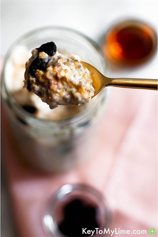Healthy maple overnight oats with cranberry on a spoon.