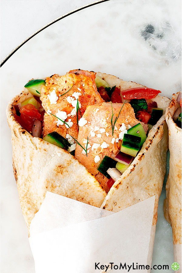 An overhead image of a single salmon gyro on a marble board.