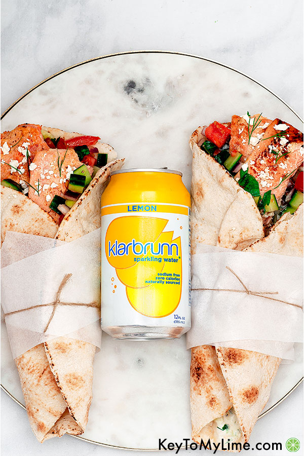An image of two salmon gyros with a can of lemon sparkling water.