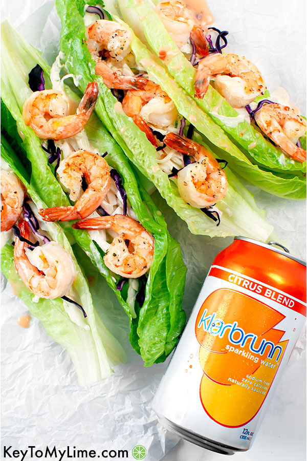 Four shrimp lettuce cups with a can or Klarbrunn sparkling water.