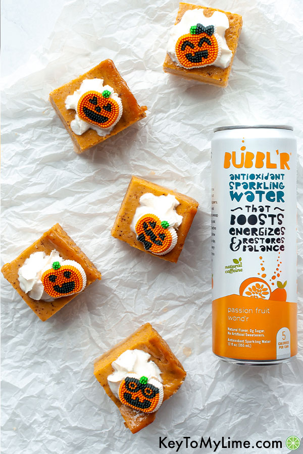 An overhead image of pumpkin bars next to a can of flavored sparkling water.