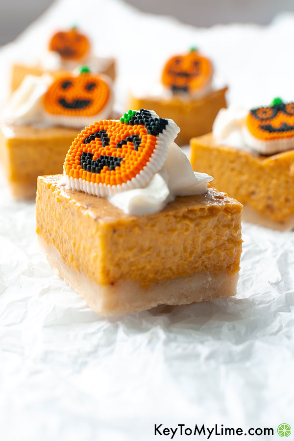 A side image of pumpkin pie bars topped with candy pumpkins.