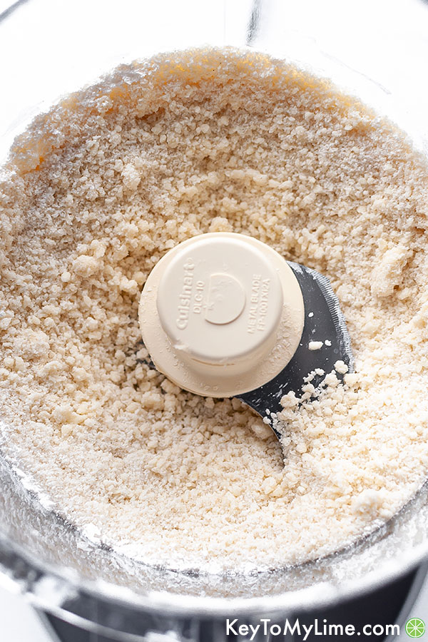 A process image showing the sandy texture of shortbread crust in a food processor.