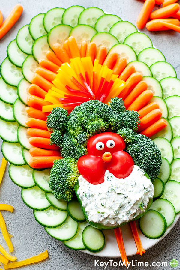 An angled image of a turkey shaped vegetable platter surrounded by scattered sliced vegetables.