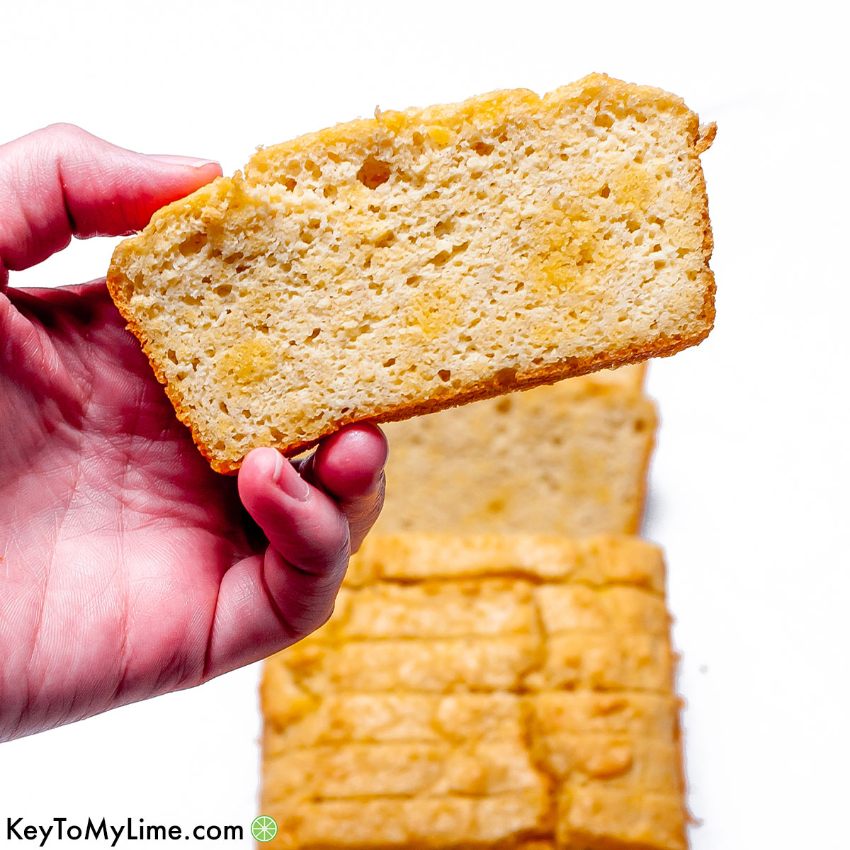 A hand holding a slice of keto bread.