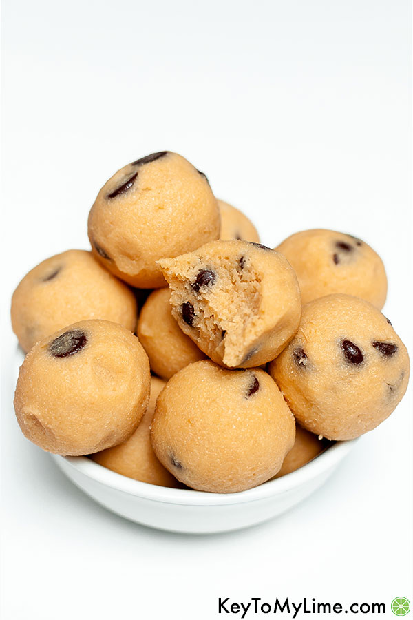 Keto cookie dough balls and one ball with a bite missing.