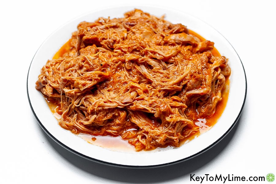 Shredded BBQ chicken on a white plate.