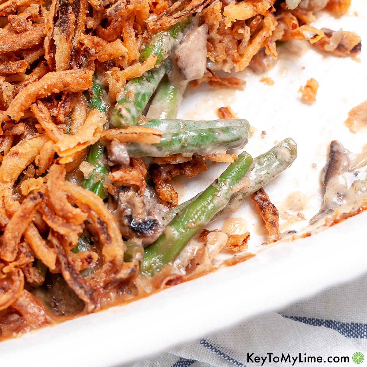 The best green bean casserole with bacon in a white baking dish.