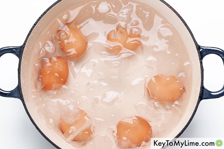 6 hard boiled eggs submerged in an ice bath.