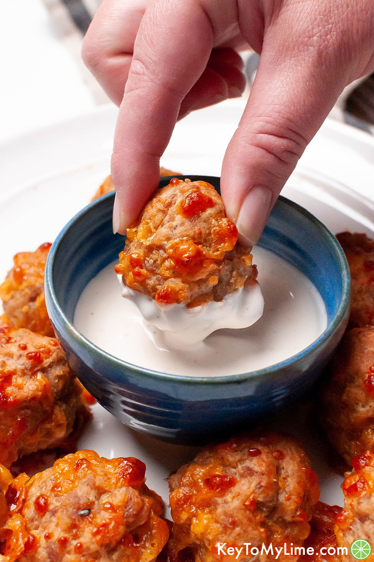 Dipping a sausage ball into ranch dressing.