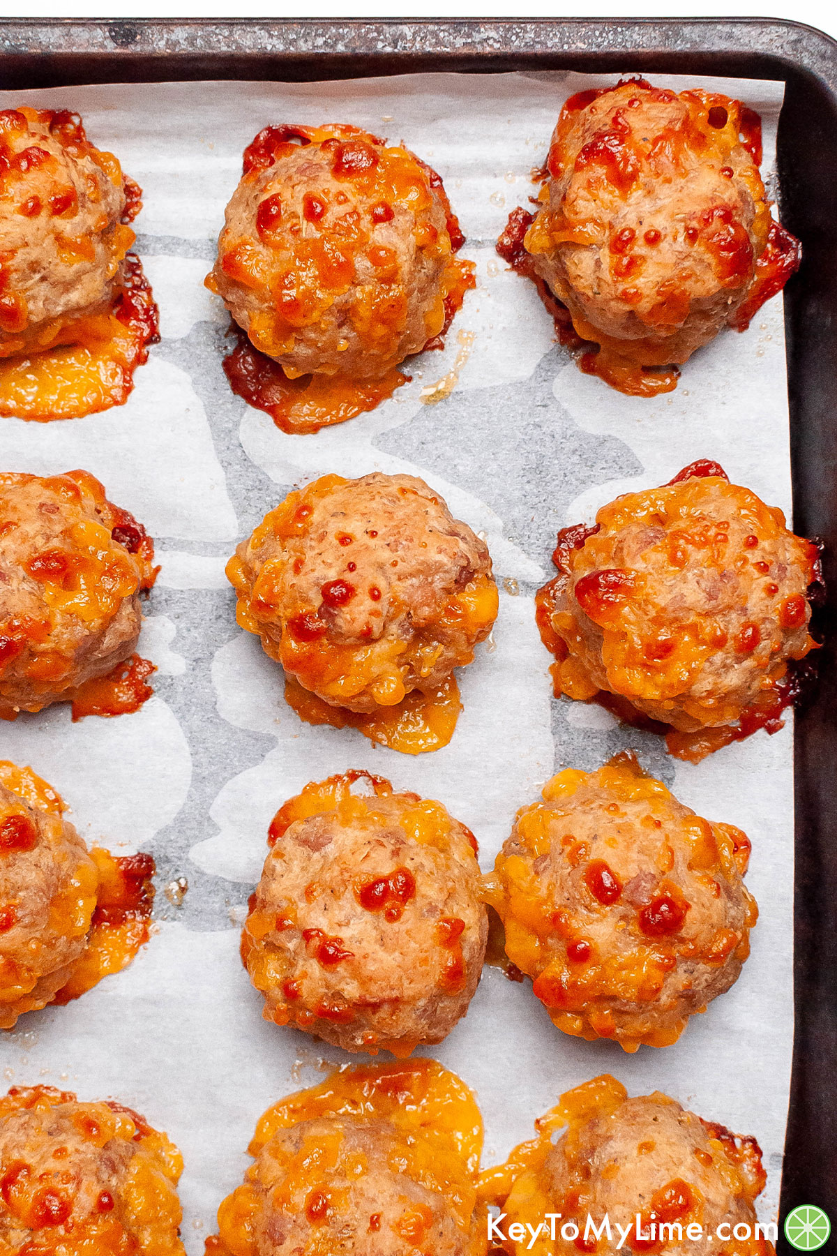 Sausage balls on a baking sheet fresh out of the oven.