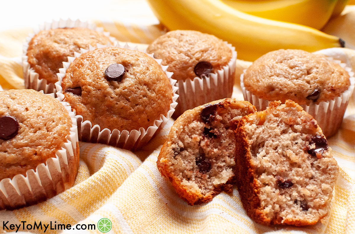 Bisquick banana muffins with chocolate chips on a light yellow cloth.