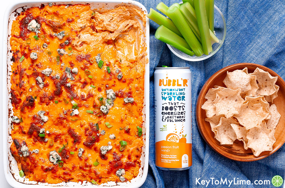 Buffalo dip next to a can of sparkling water.