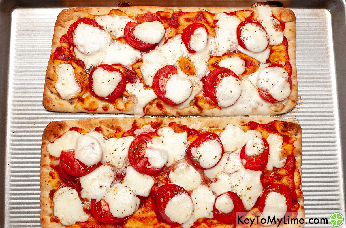 Two flatbread pizzas fresh out of the oven.