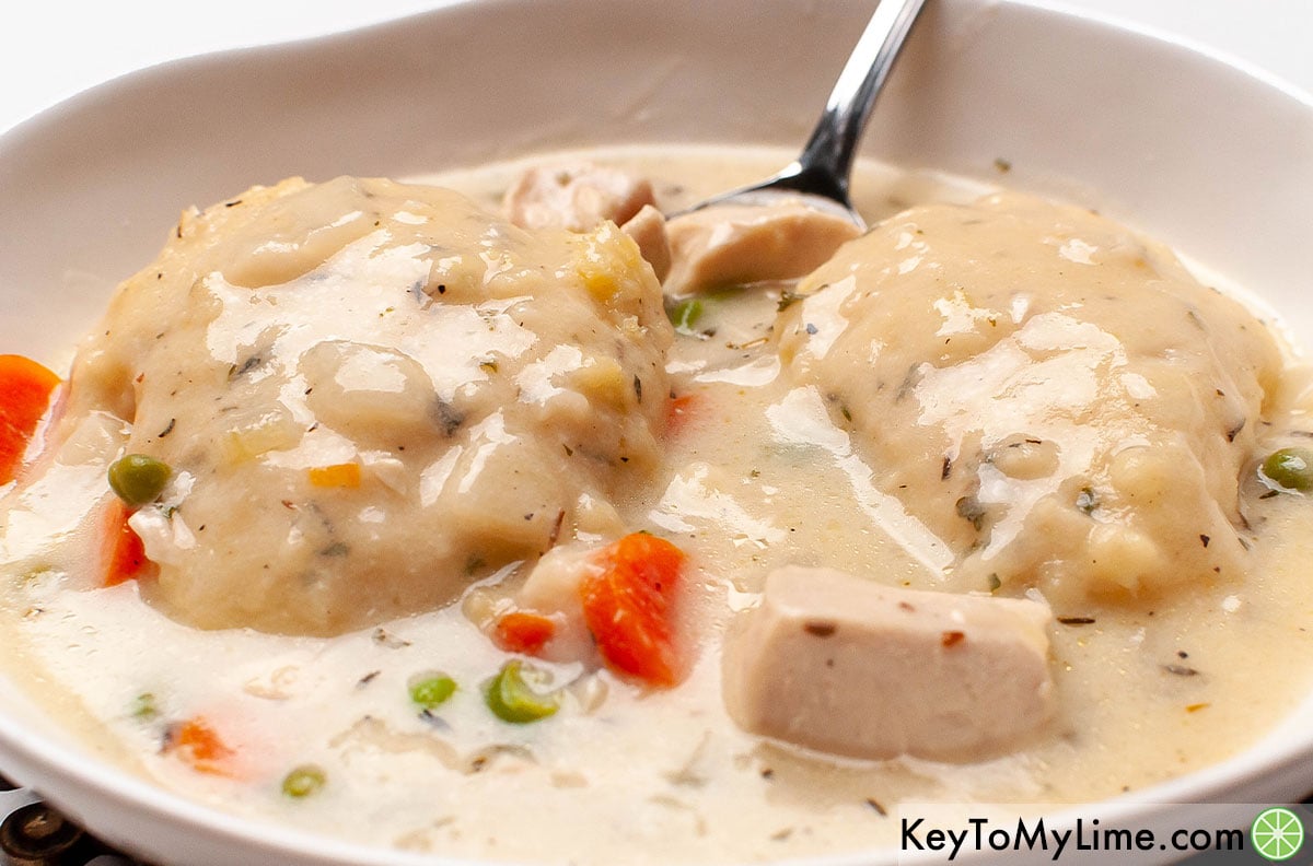 A bowl of Bisquick chicken and dumplings with a spoon in the bowl.