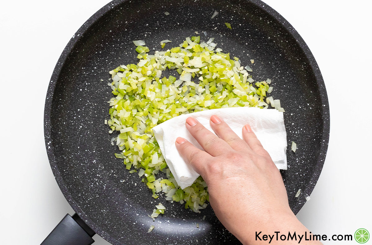 Using a paper towel to dab the excess moisture off of sauteed onion and bell pepper.