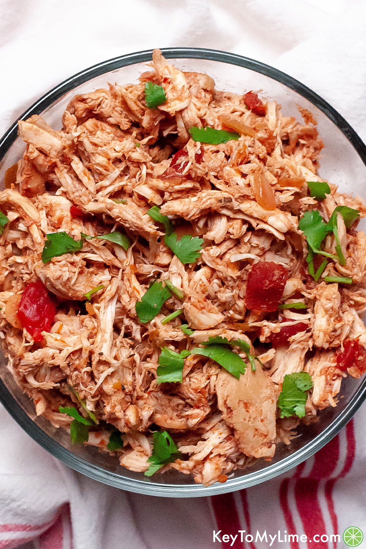 A close up image of a bowl of shredded slow cooker salsa chicken.