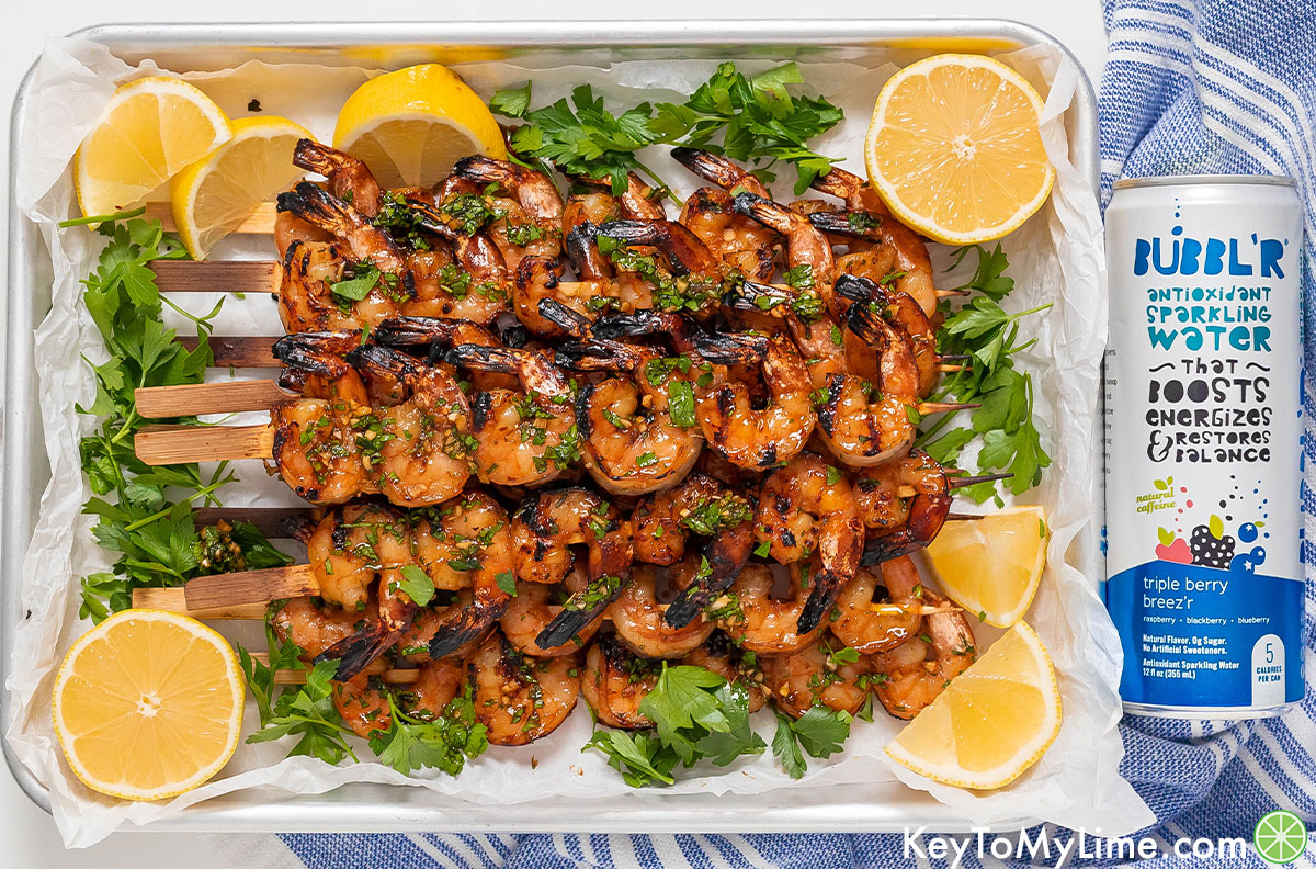 Grilled shrimp kabobs next to a can of BUBBL'R sparkling water.