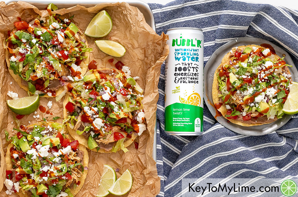 An image of multiple chicken tostadas next to can of sparkling water.
