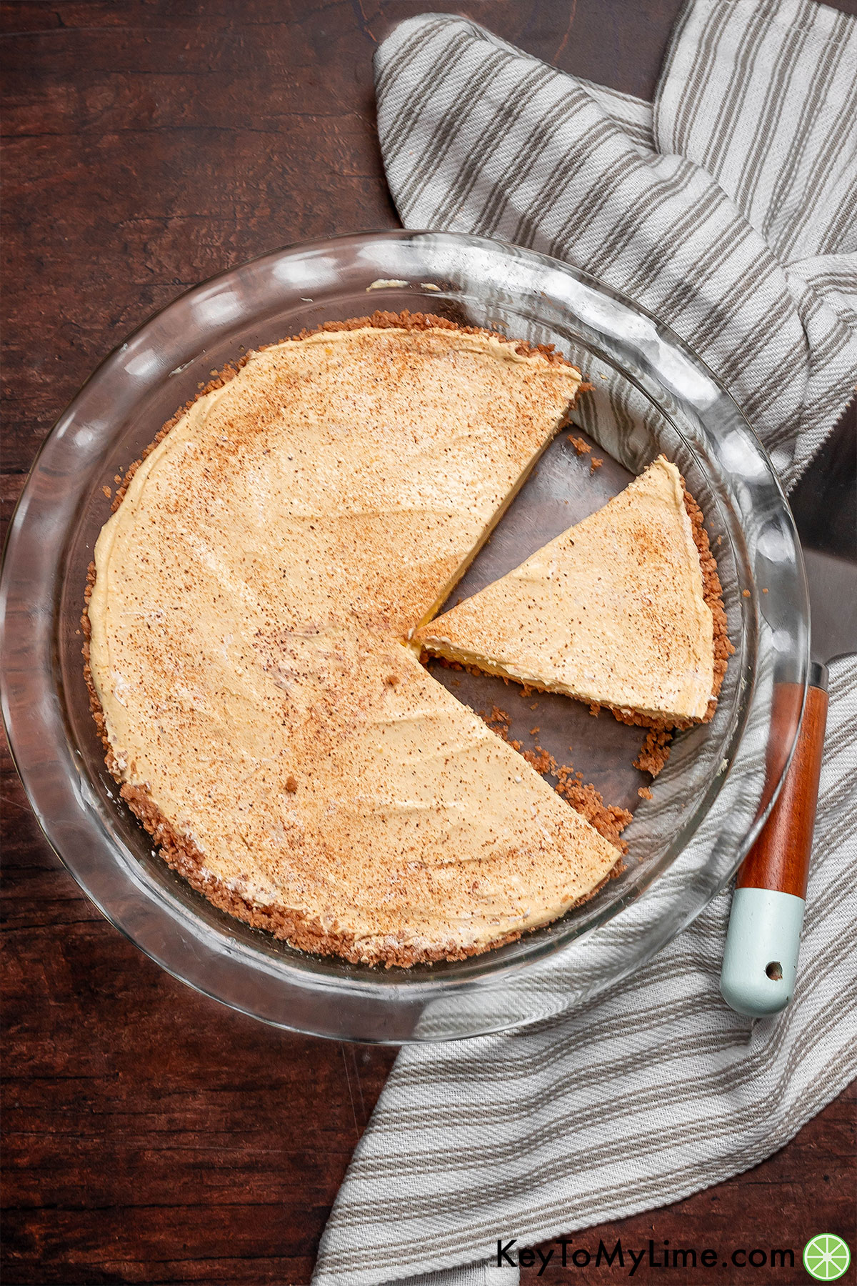 An overhead image of an eggnog pie in a pie dish with slices missing.