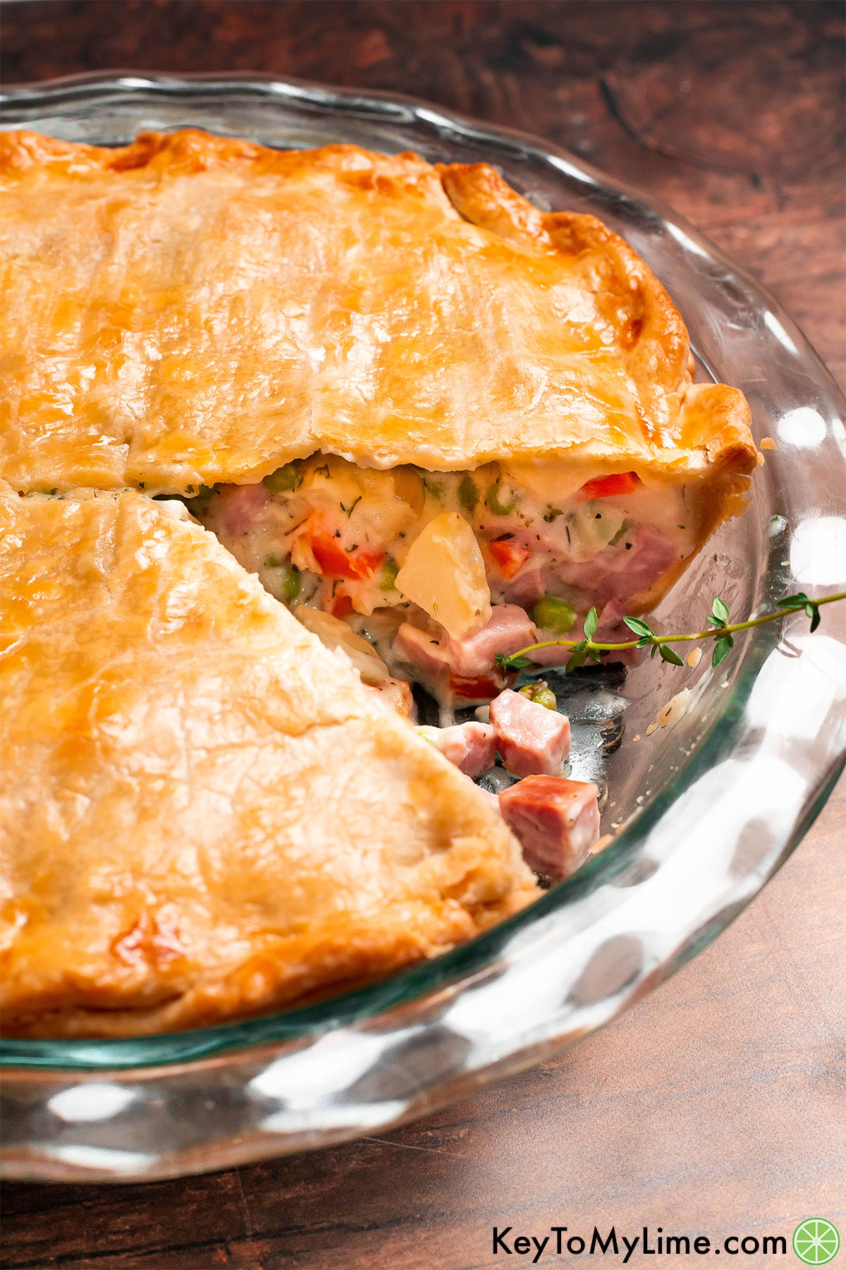 A golden crust ham pot pie with thick creamy filling showing.