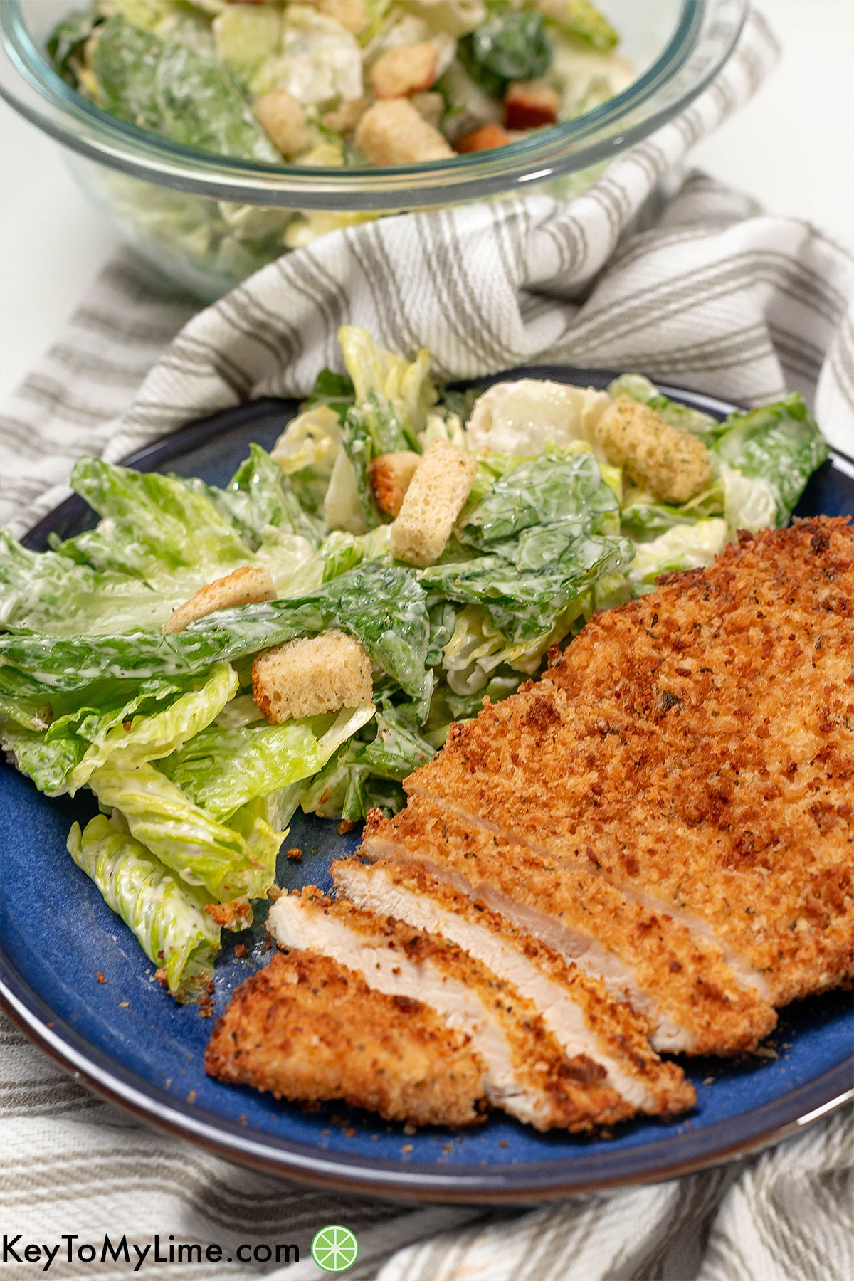 A side shot of a sliced crispy chicken cutlet showing the inside texture.