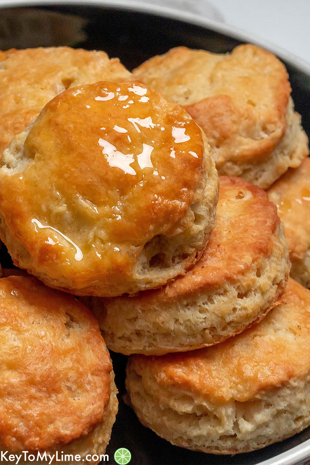 A close up photo of flakey biscuits with melted butter on top.