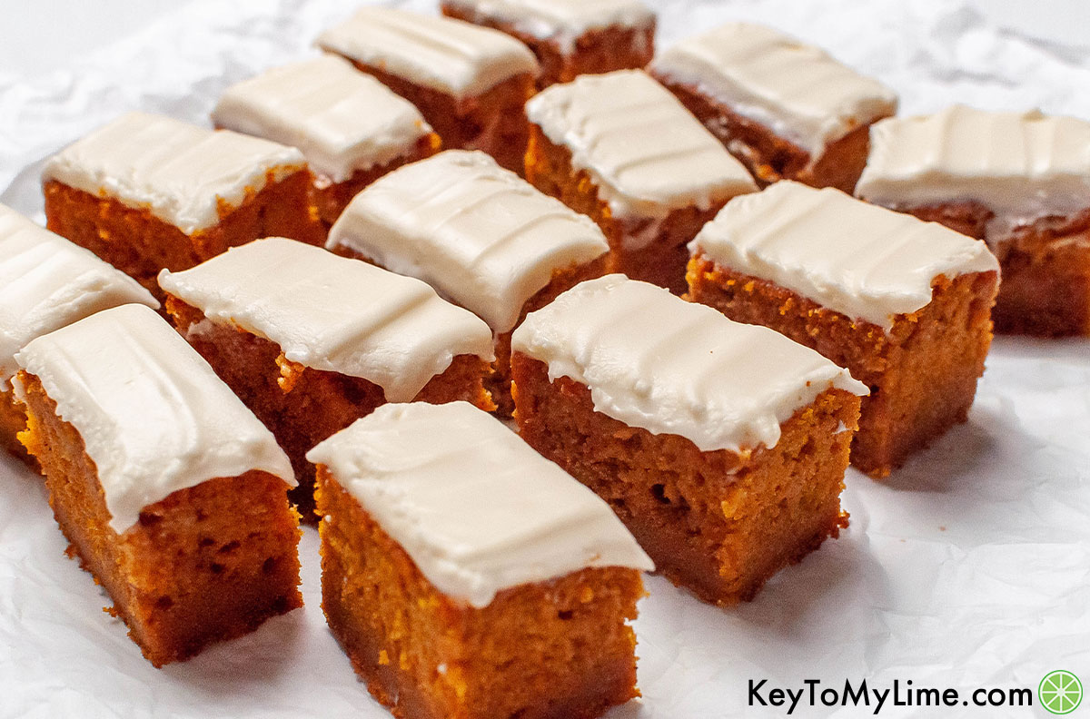A spread of delicious and fluffy pumpkin bars with frosting on top.