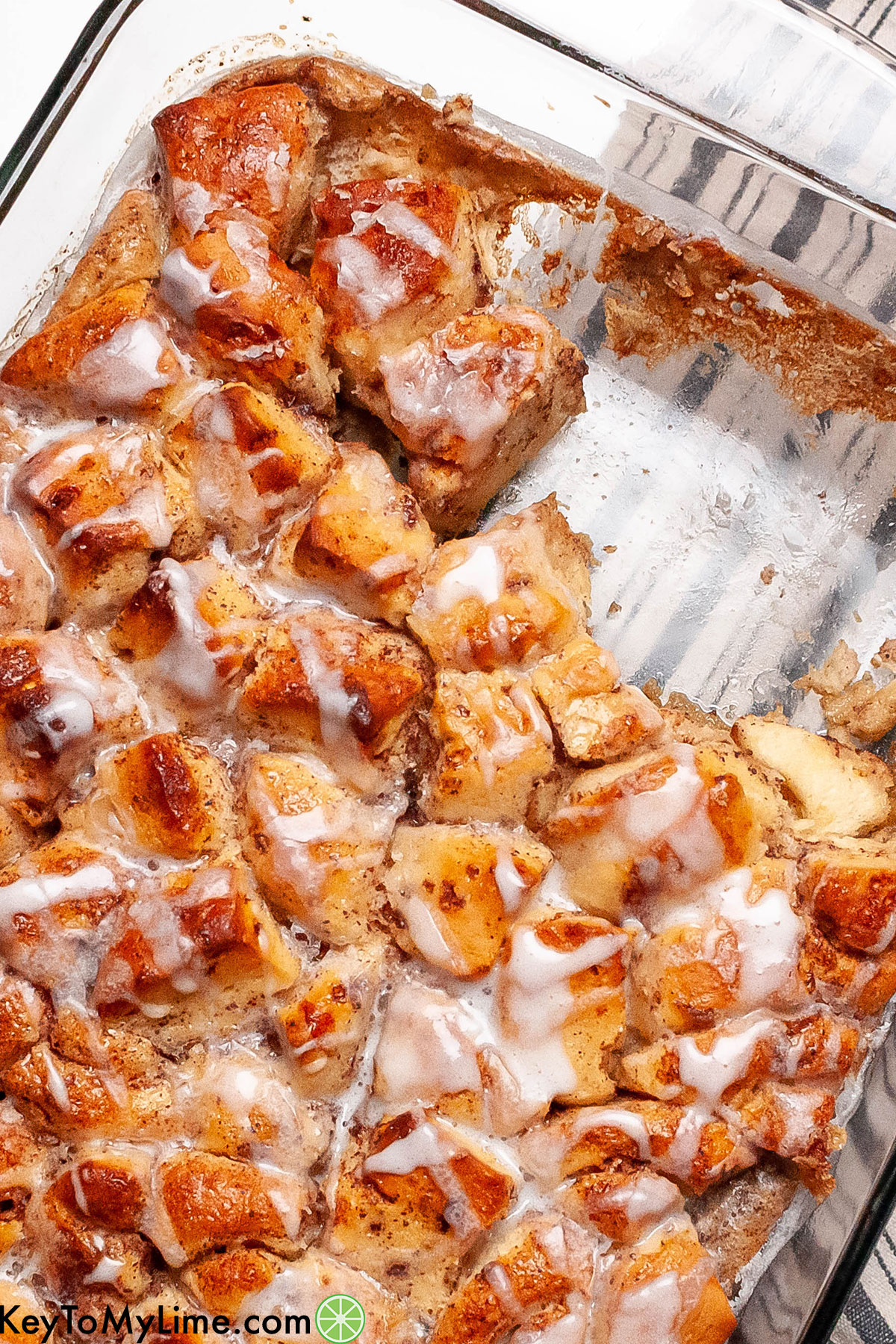 A delicious cinnamon roll casserole in a casserole dish with a piece missing.