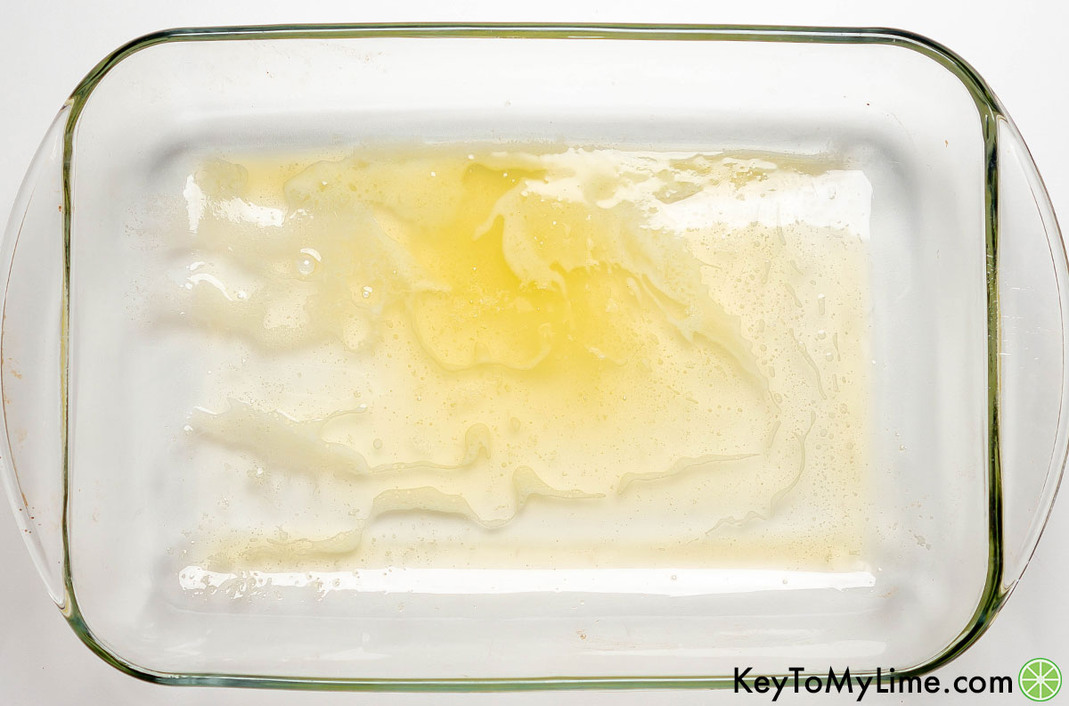 Melting the butter and spreading in a casserole dish.
