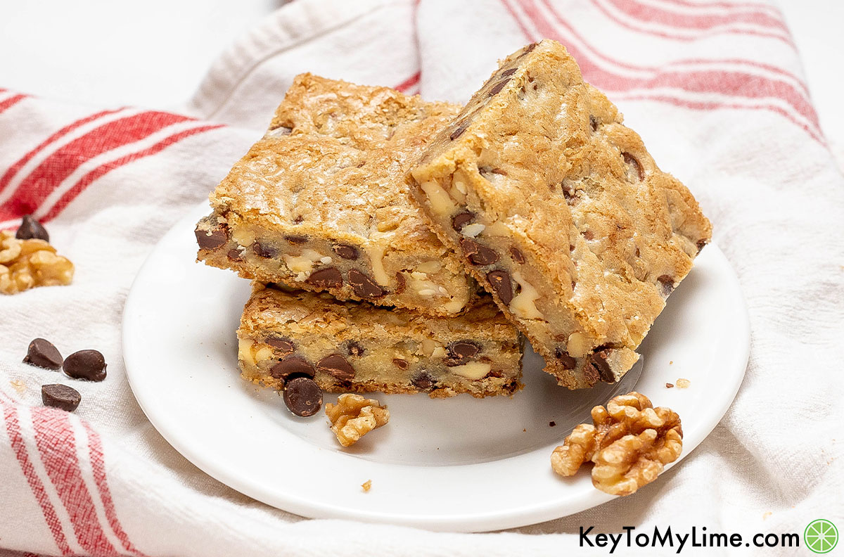 A stack of chocolate and walnut cookie bars served on a white dish.