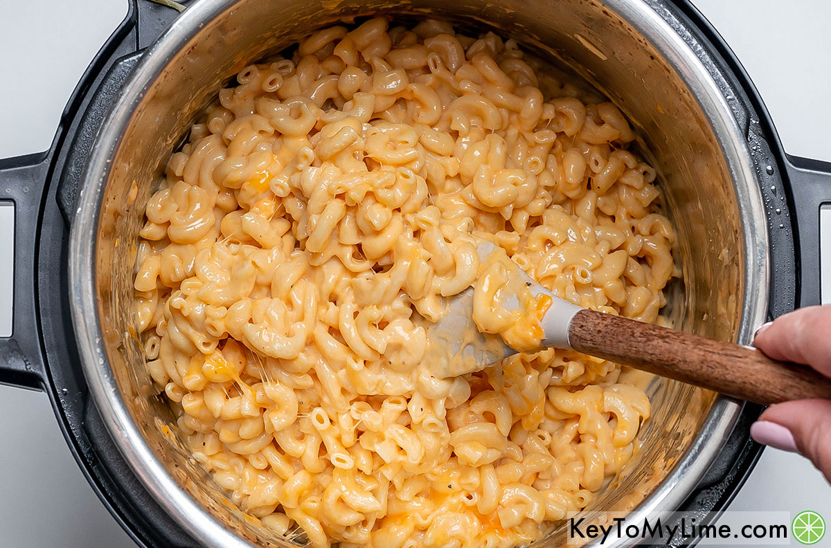 Mixing in the three cheeses until fully incorporated with the pasta mixture.