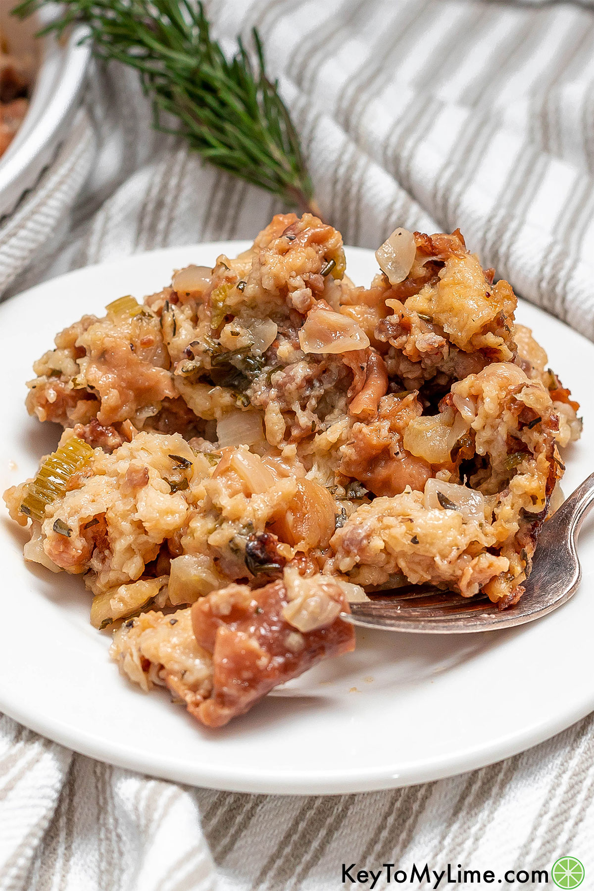 A serving of stuffing on a white dish showing the texture of the stuffing.