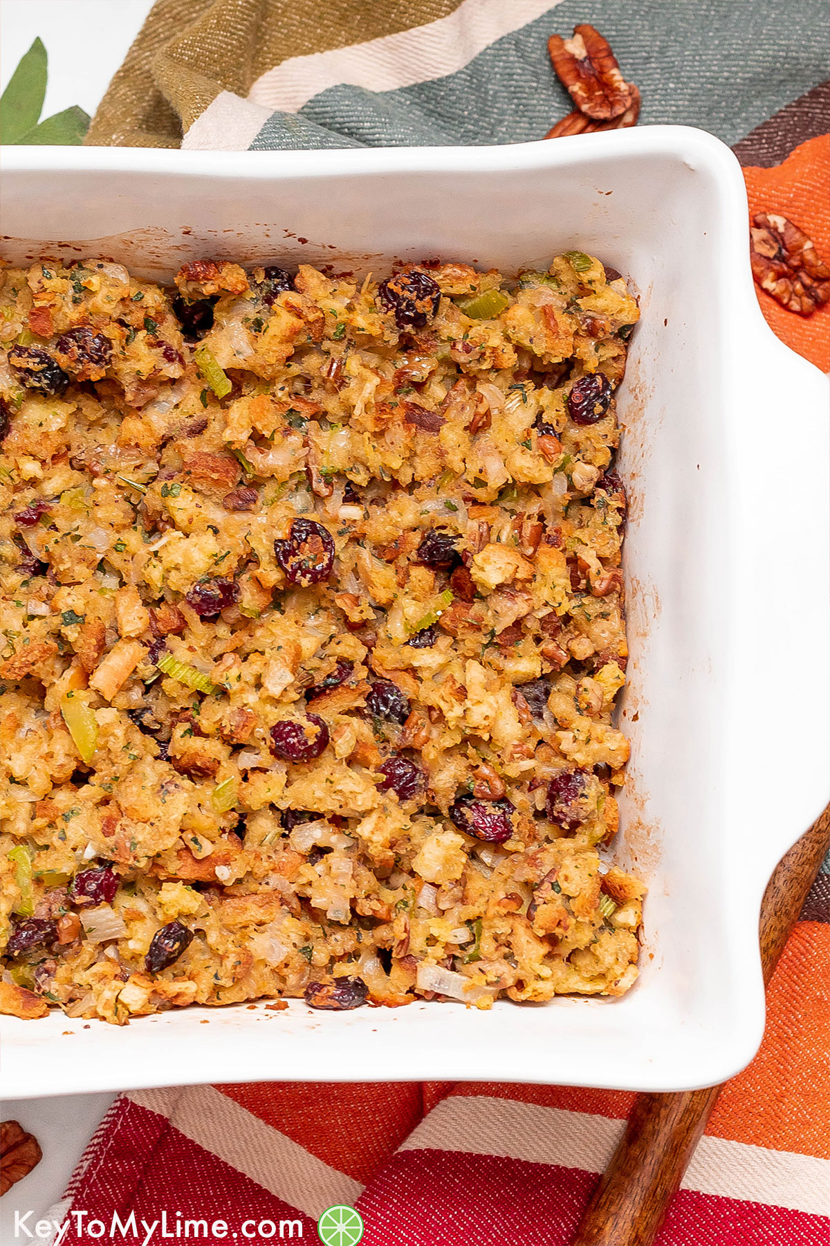 A casserole dish filled with freshly baked stuffing with cranberries and celery throughout.