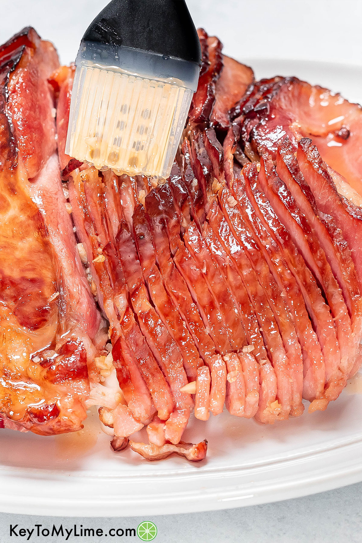 Brushing the ham with the glaze after being broiled in the oven.