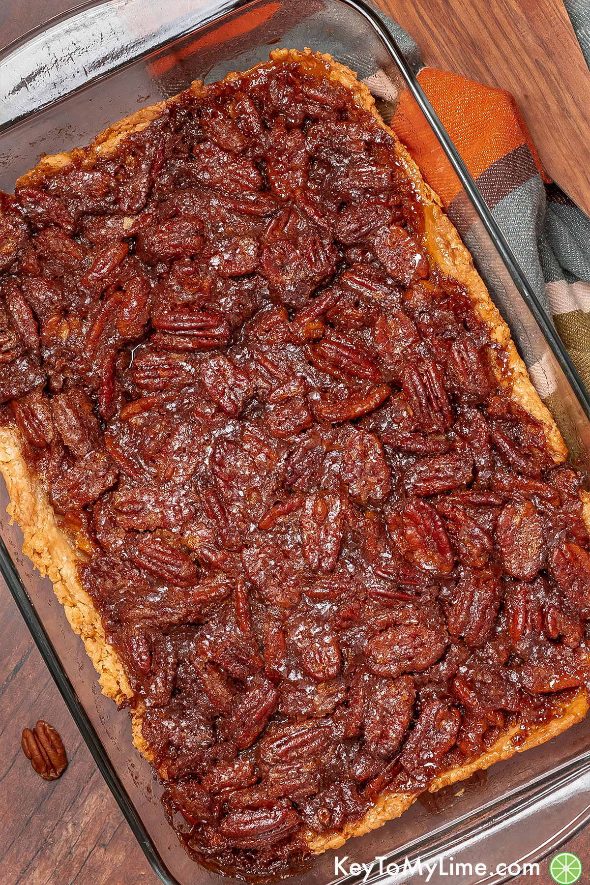 An angled image of a finished pecan cobbler with a layer of caramelized pecans.