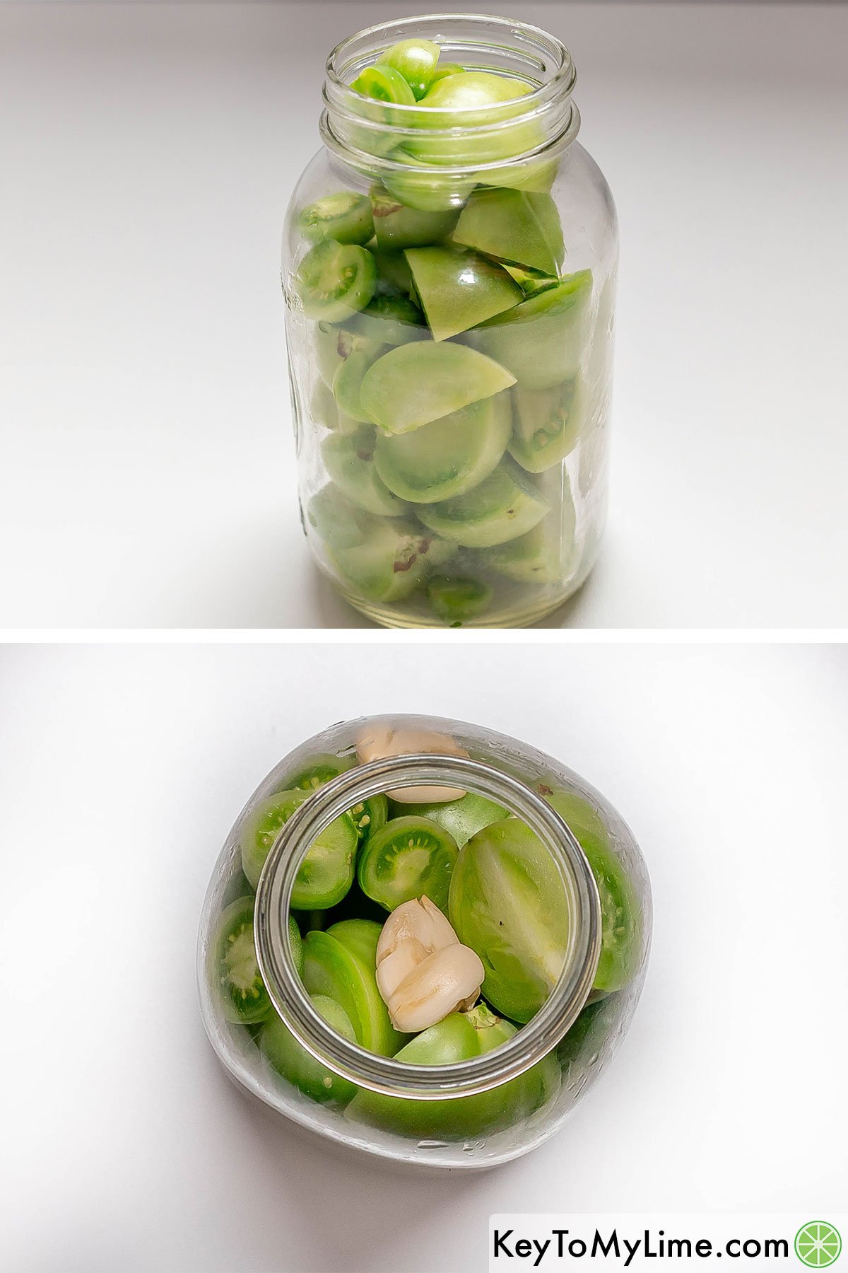 Filling the glass jar up with cut green tomatoes and adding in pressed garlic cloves.