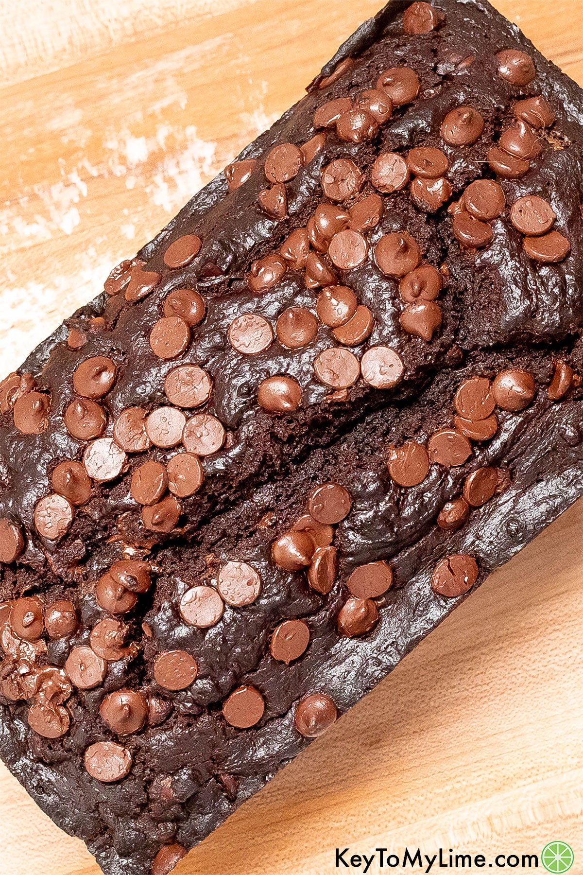 Gooey chocolate chips glistening on top of a chocolate loaf cake.