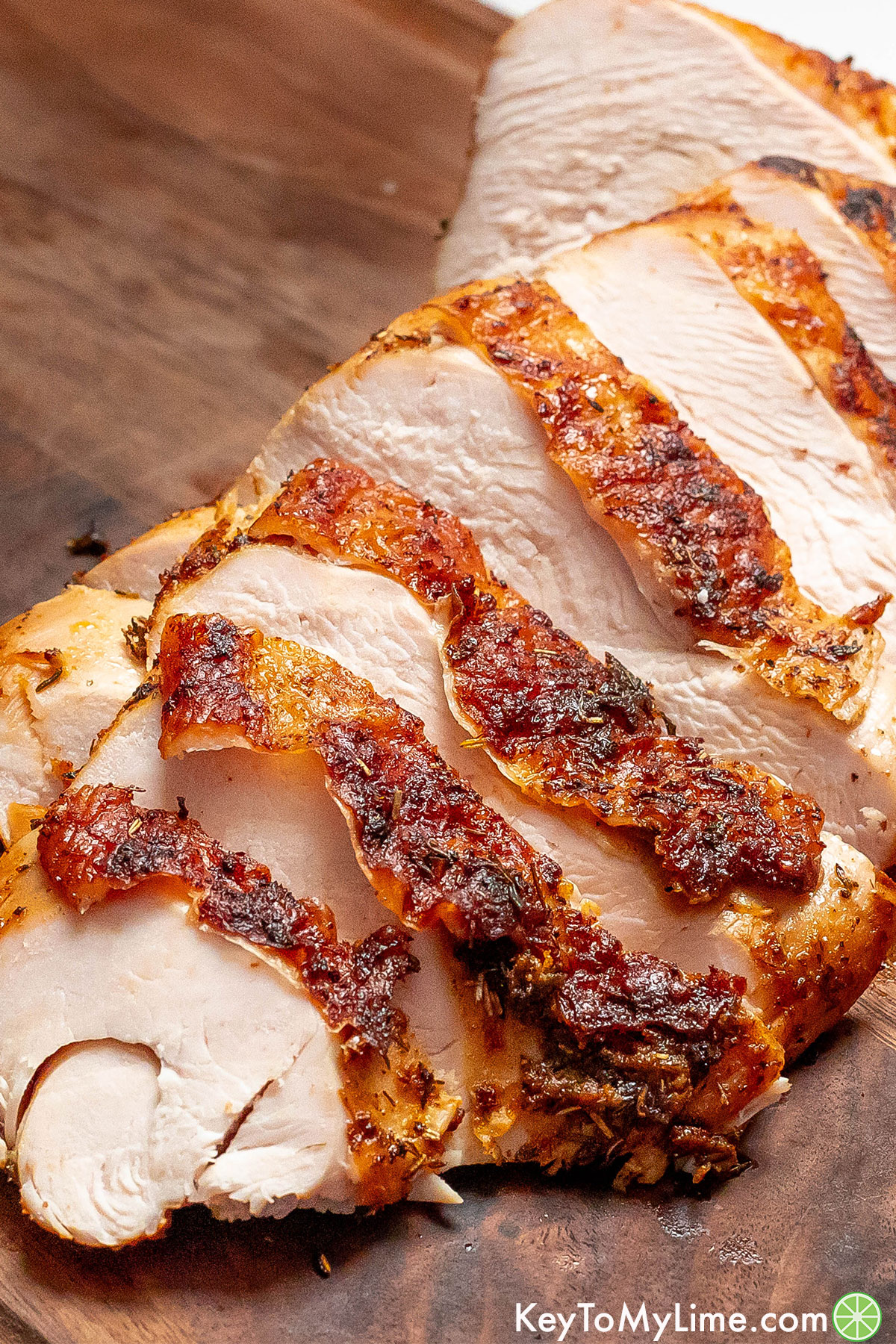 A brined turkey breast cooked and sliced on a cutting board.