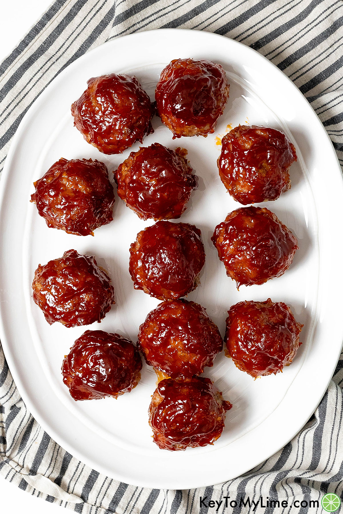 An overhead image of glazed ham balls on a large serving tray without garnish.