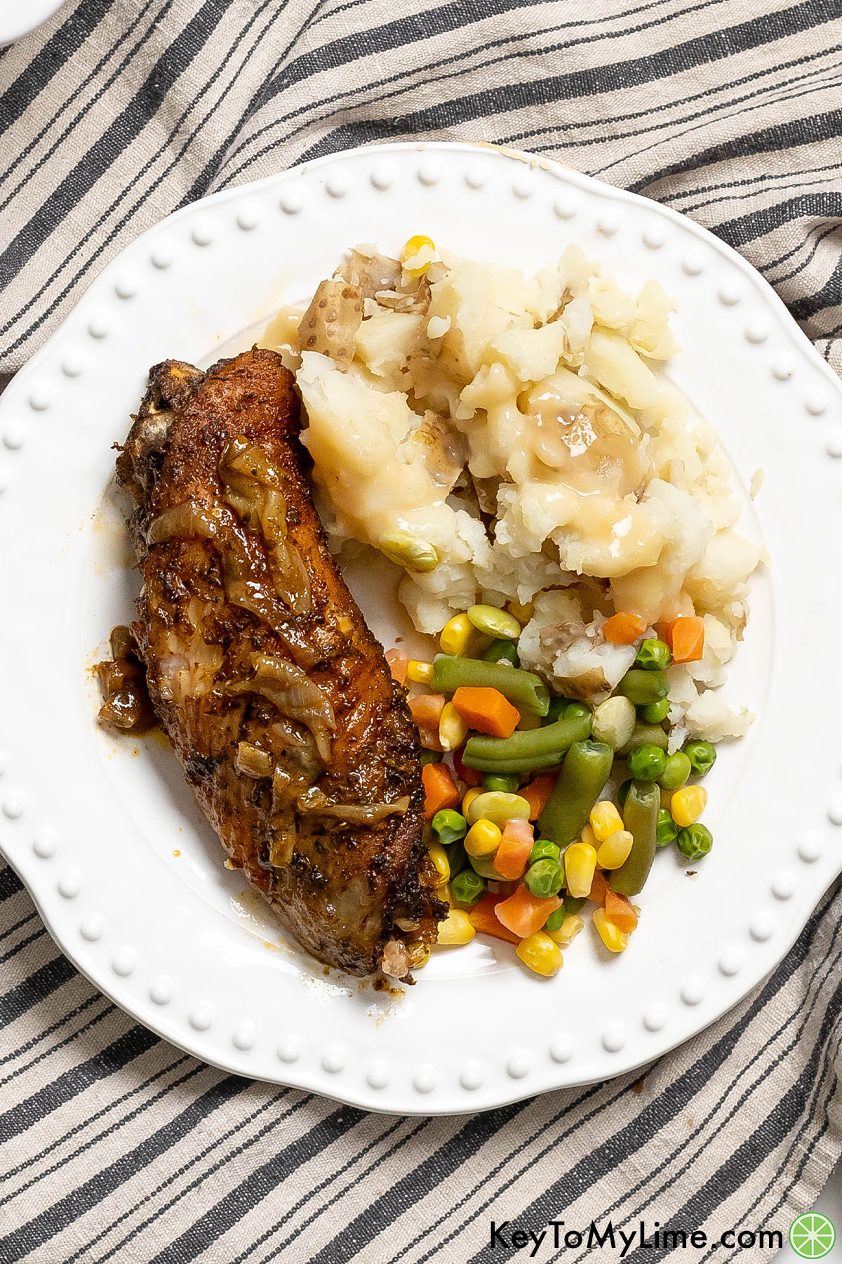 An overhead images of a plated turkey dinner with mixed vegetables and potatoes to the side.