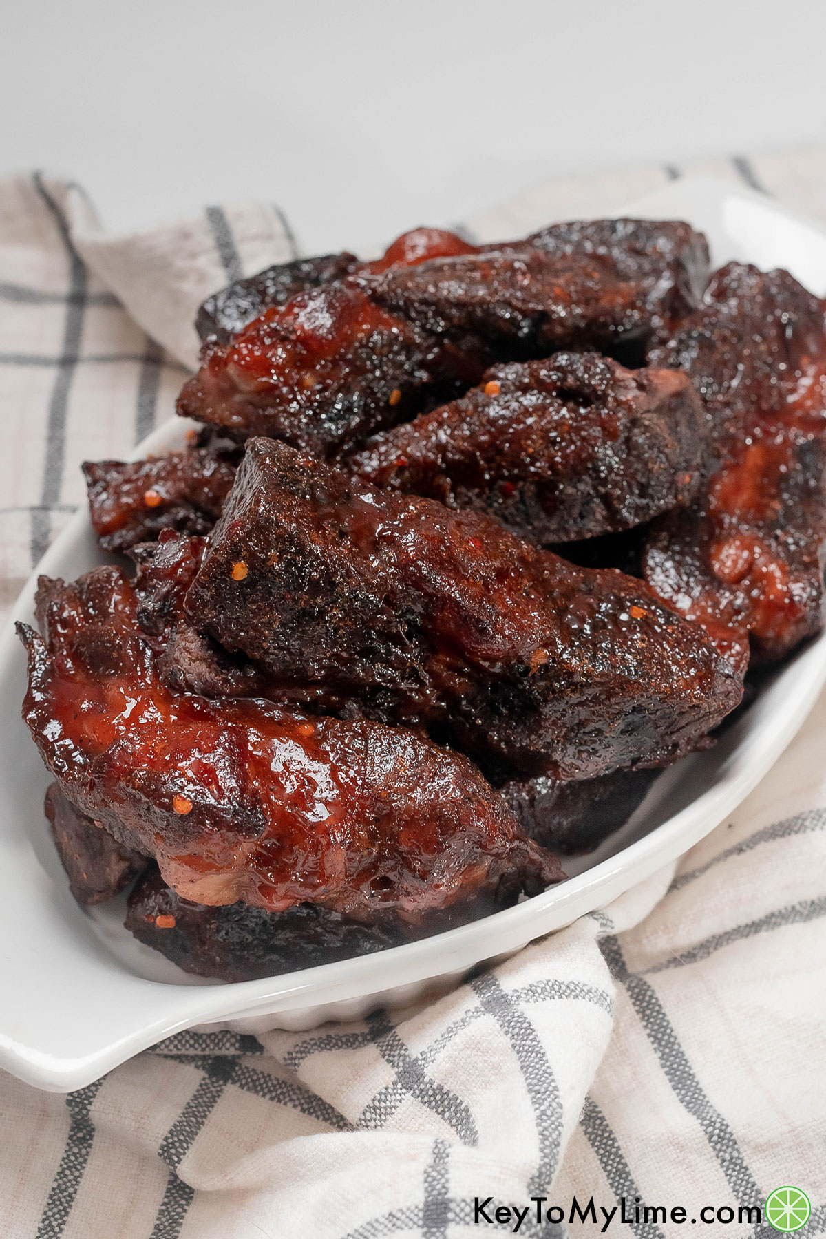 A pile of oven baked ribs with red pepper flakes throughout.