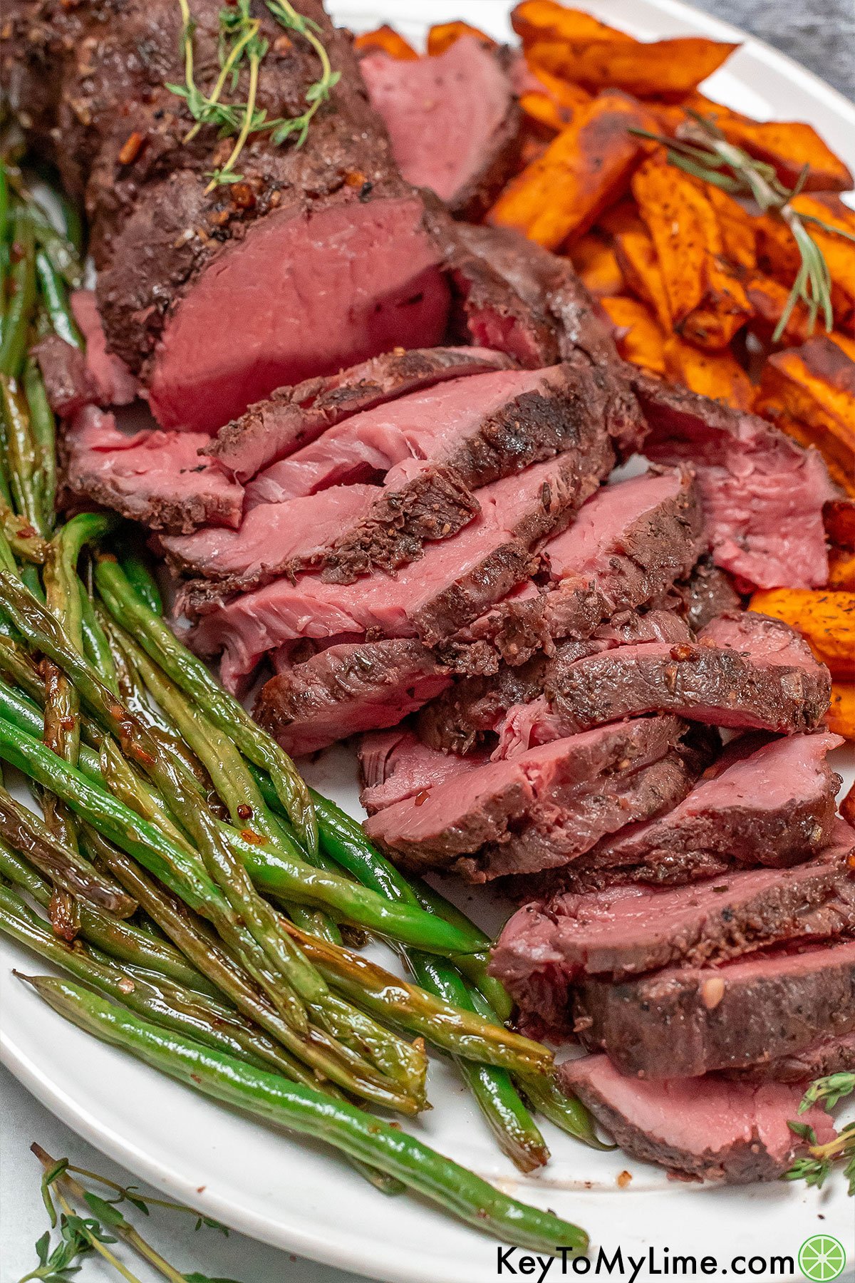 A beautiful tenderloin beef dinner platter with sweet potatoes and asparagus.