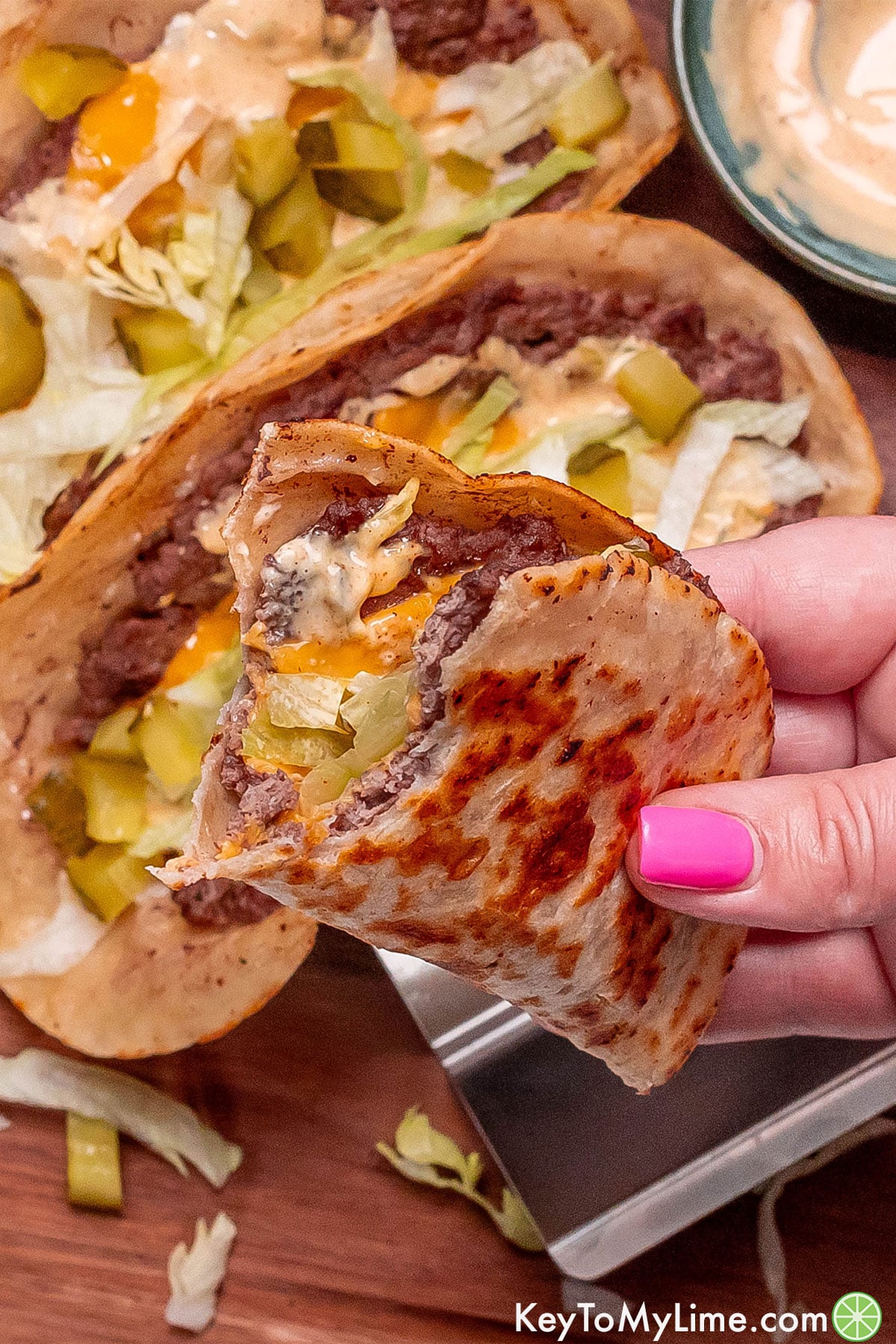 A close up image of a partially eaten big mac taco showing the texture.