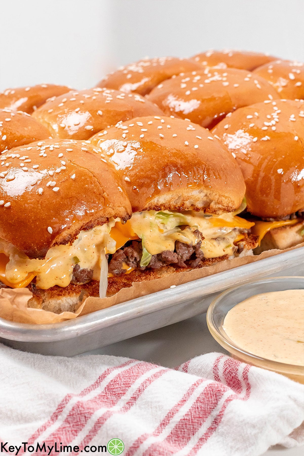 A side image of fully cooked sliders with melted butter glistening on top.