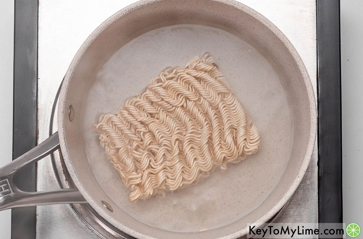 Adding ramen noodles to a small pot, and then boiling and cooking for 3 minutes.