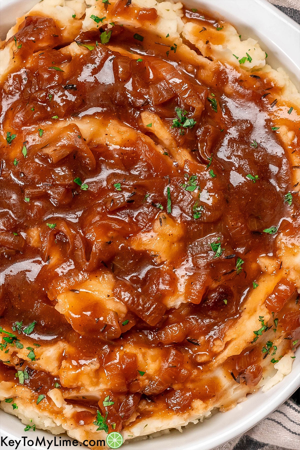 A close up image of gravy smothered on mashed potatoes.