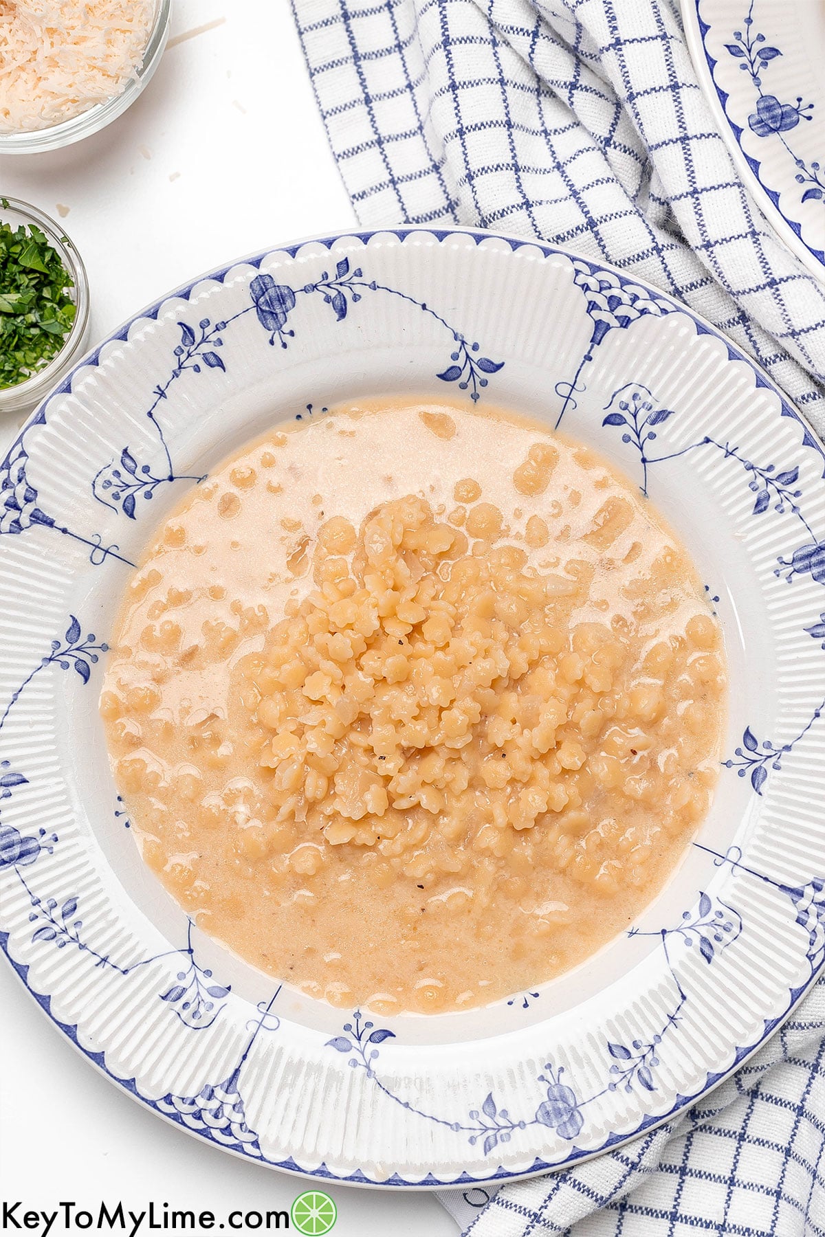 An overhead image of a soup dish with garnish to the side.