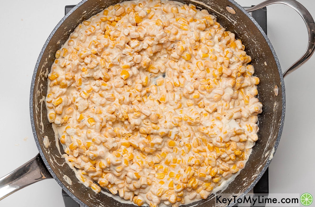 Stirring the creamy corn occasionally until the butter, cream, and cheese has fully melted.